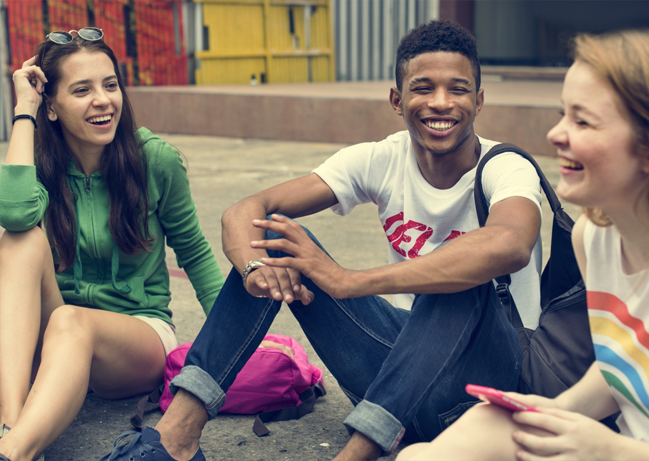 Image of 3 young people sat outside having a chat.